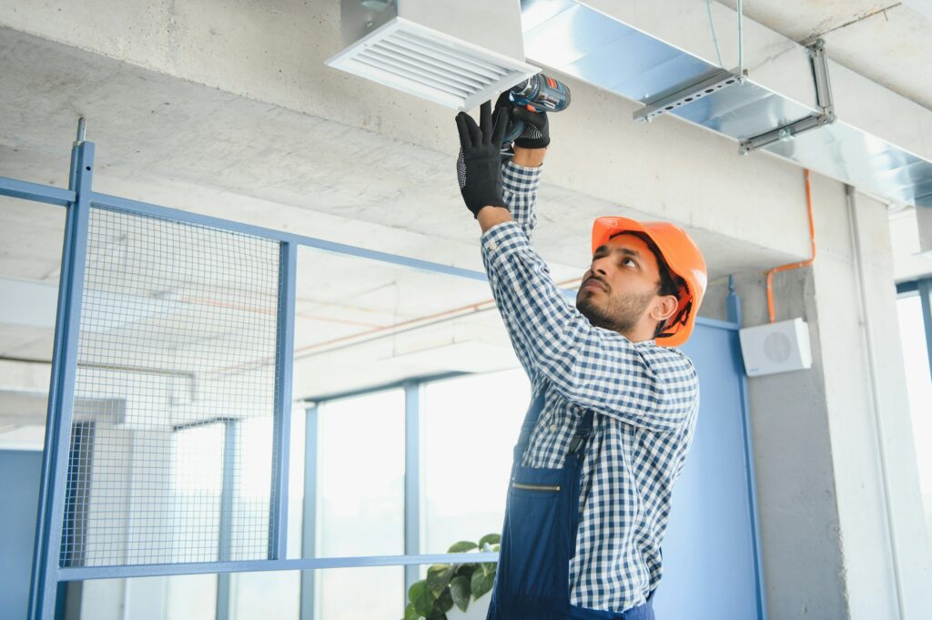 Ventilation cleaning. Specialist at work. Repair ventilation system (HVAC). Industrial background